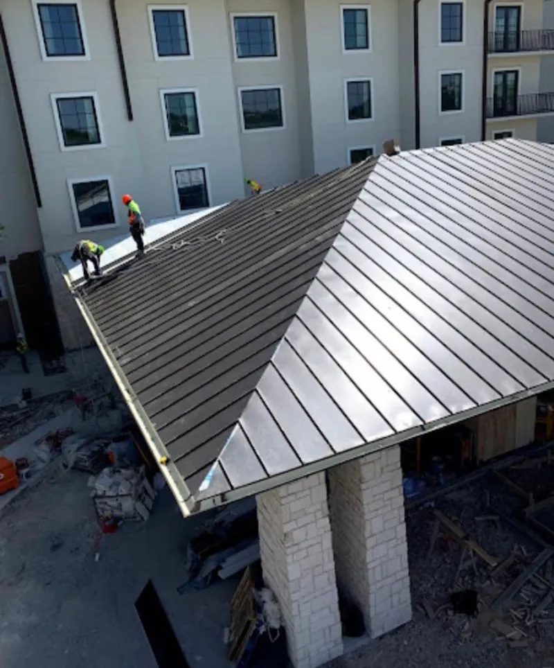 Crew installing standing seam metal roof panels on a commercial project in Santa Cruz